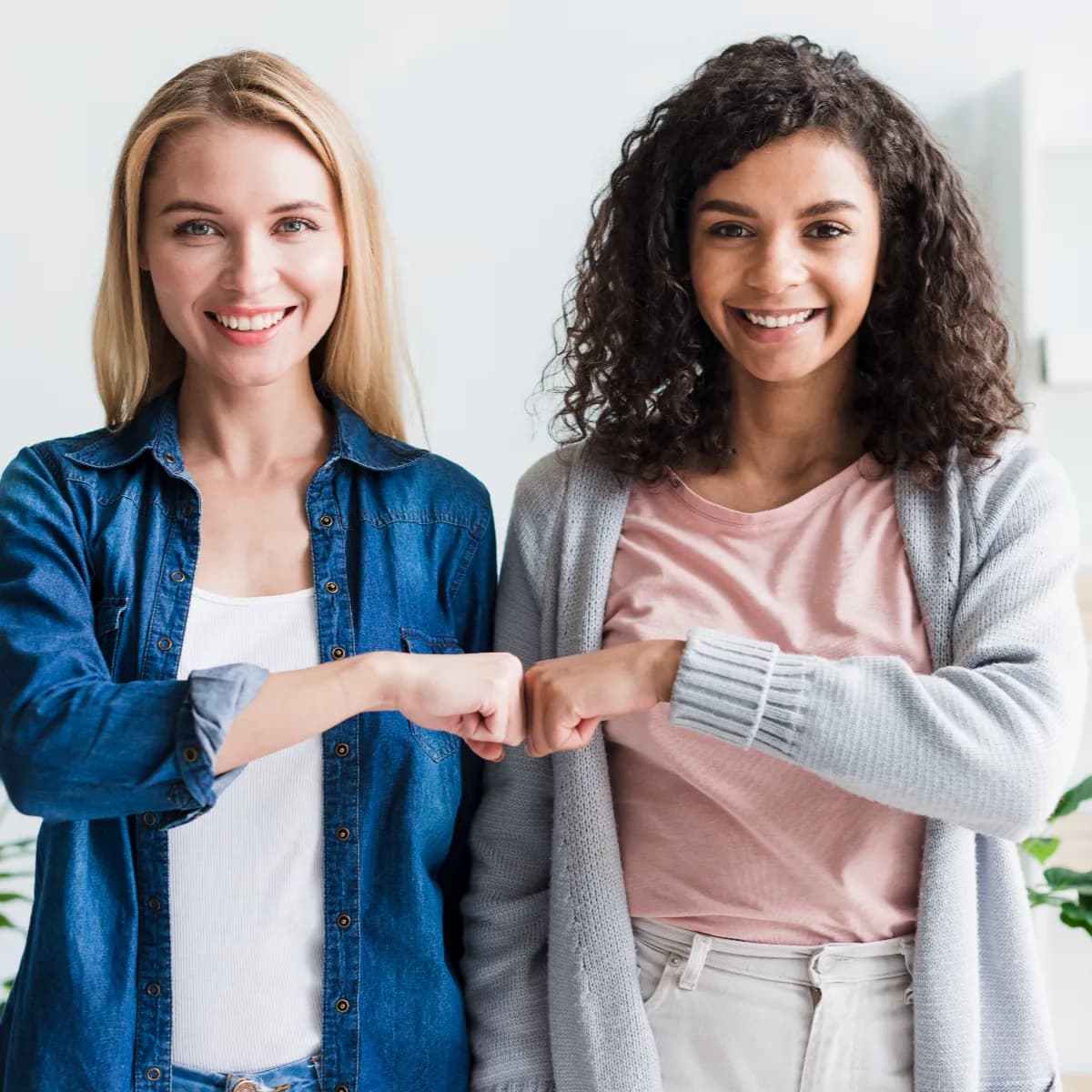 multiracial-employees-bumping-fists-office